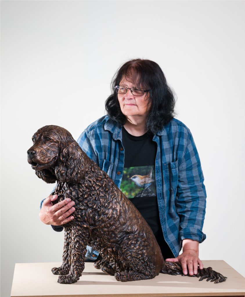 Sculptress JOEL in the studio with the cast bronze statue of the dog Jasper