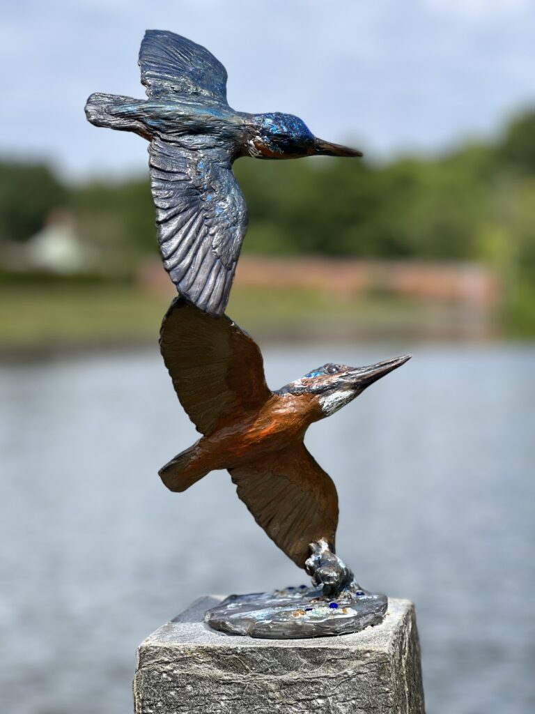 Pair of Bronze Kingfishers by Sculptress JOEL and set against a lake vista