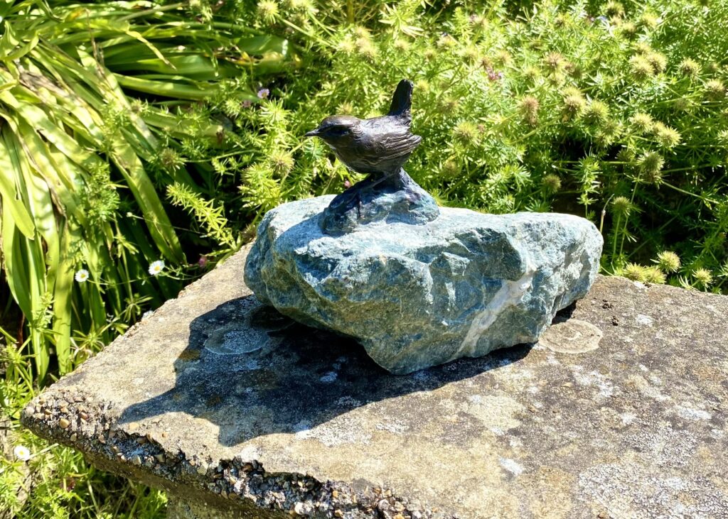 Wren bronze sculpture a bird set on a green rock by the Sculptress JOEL